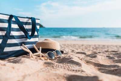 Torba, kapelusz, okulary i rozgwiazdy leżące na plaży